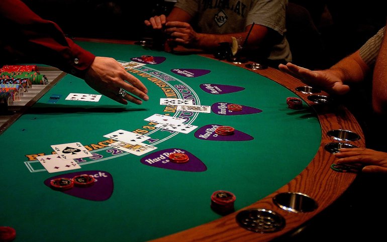 Der Croupier zeigt auf die Karten im Blackjack-Spiel